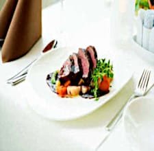 Steak served on an elegant plate with forest sauce and fresh vegetables.