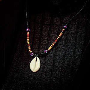 A handmade DIY necklace with colorful beads and mussel shells.