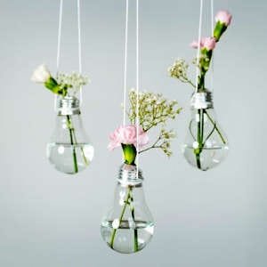 A creative light bulb turned into a small vase, holding a tiny flower for a unique decorative touch.