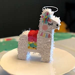 A colorful handmade llama piñata, decorated with vibrant paper for a fun and festive touch.